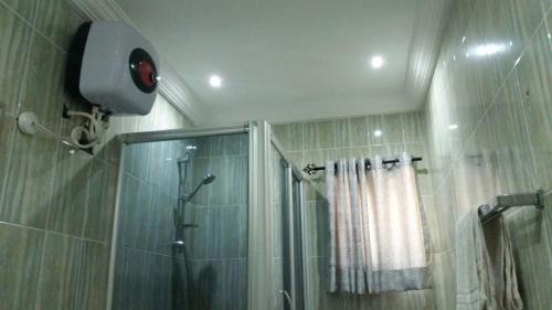 a bathroom with a shower with a shower curtain at Paris Suites in Festac Town