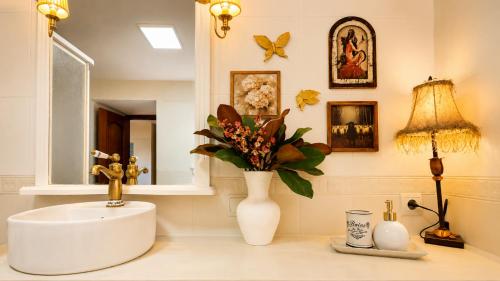 a bathroom with a sink and a vase with flowers at La Venta de Pedro in Ribadesella