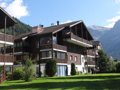 a building on a hill with mountains in the background at Apartment Dorfstrasse 53a by Interhome in Engelberg