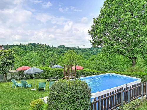 a swimming pool with chairs and umbrellas in a yard at Holiday Home Il Cavaliere by Interhome in Castellero