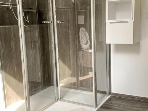 a shower with glass doors in a bathroom at Apartment Am Wald by Interhome in Westerstede
