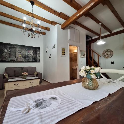 a bedroom with a table with a vase of flowers on it at Casa di Sofiana by wood and stone in Áyios Pétros