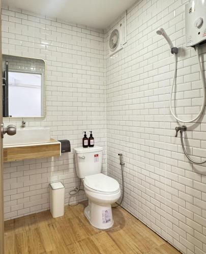 a white bathroom with a toilet and a sink at ลิตเติ้ล แคมป์ ชะอม in Ban Bung Mai