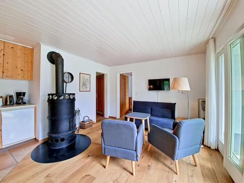 a living room with a stove and two chairs at Apartment Chalet Holzwurm-1 by Interhome in Grindelwald