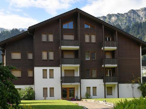 an apartment building with balconies and mountains in the background at Apartment Dorfstrasse 53c by Interhome in Engelberg