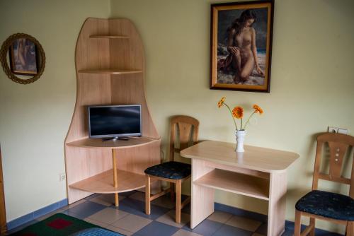 a room with a desk and a tv and a table at Eiva in Marijampolė