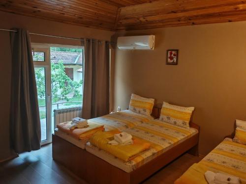 a bedroom with a bed and a large window at Hotel Valdis in Pastra