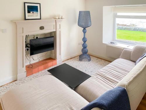 a living room with a couch and a fireplace at Tigh An Dun in Luib