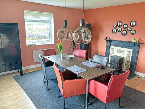 a dining room with a table and red chairs at Tigh An Dun in Luib