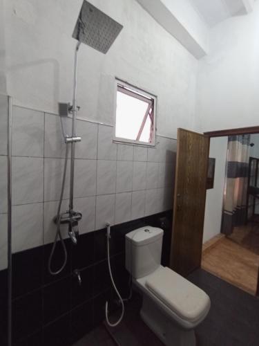 a bathroom with a toilet and a window and a shower at 39 House Weligama in Weligama