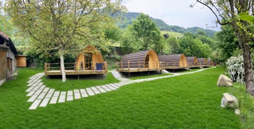 a row of tents in a field of grass at Traumhafter POD-M mit Seesicht - mit Terrasse aber ohne privates WC in Alpnach