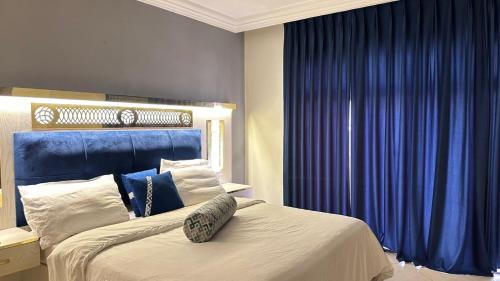 a bedroom with a large bed with blue curtains at فندق كلاسيك in Aqaba