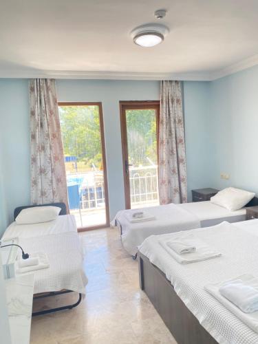 a bedroom with two beds and a window with a view at Emir Palas Hotel in Ekincik