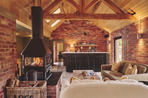 a living room with a fireplace and a brick wall at Haymill Retreat in Trefeglwys