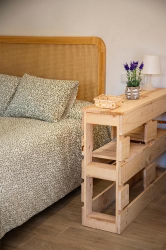 a bedroom with a bed and a wooden table with a night stand at Casa Rural La Posada del Quijote in Puerto Lápice