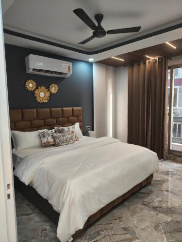 a bedroom with a large bed with a ceiling fan at 12 Summits Elite Stays in Dehradun