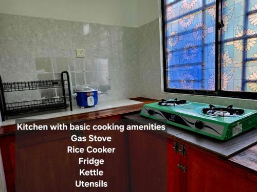 a kitchen with basic cookingentials gas cooker fridge at Osvy Palm Homestay in Penampang