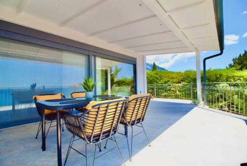 a patio with a table and chairs on a balcony at PNOẼ Luxury Apartments in Lourdata