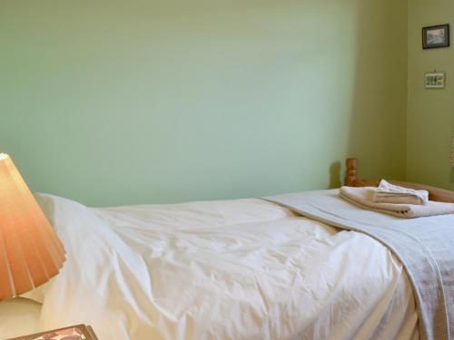 a bed with white sheets and towels on it at Cass Lodge in Huby