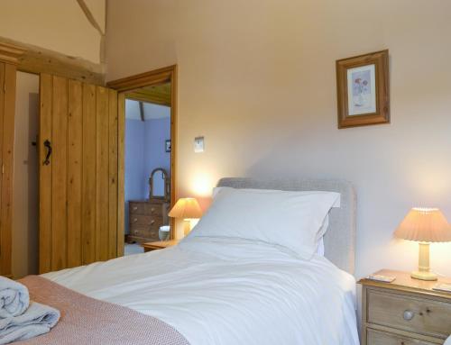a bedroom with a white bed with two lamps on a night stand at Cass Lodge in Huby