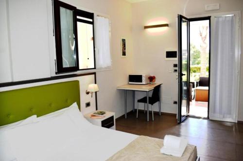 a bedroom with a bed and a desk with a computer at Tenuta Espada Gallipoli in Gallipoli