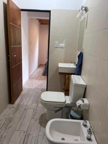 a bathroom with a toilet and a sink at Cabañas Nido Escondido in Villa Ciudad Parque