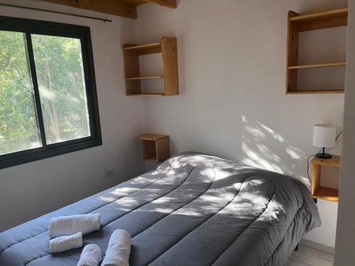 a bedroom with a large bed in a room with a window at Cabañas Nido Escondido in Villa Ciudad Parque