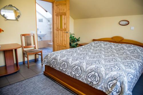 a bedroom with a bed and a table and a chair at Eiva in Marijampolė