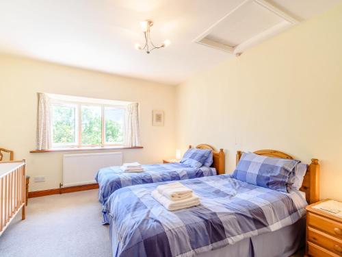 a bedroom with two beds and a window at Town Head Cottage in Carlton