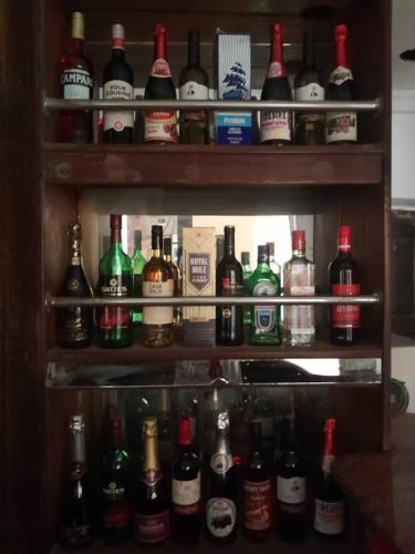 a shelf filled with lots of bottles of alcohol at St Nicholas Guest Inn in Galadima