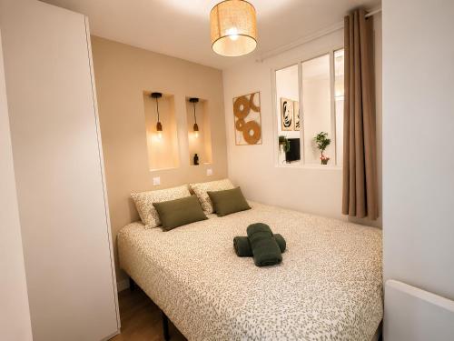 a bedroom with a bed with a green stuffed animal on it at Saint Maclou Plein Centre Rouen Malpalu - Linge & Ménage Inclus in Rouen