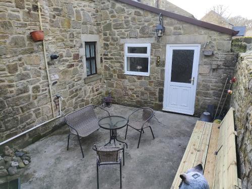 a patio with a table and chairs and a building at Riverside Cottage - Uk32405 in Stanhope