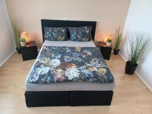 a bed with a floral quilt on it in a bedroom at Ebenerdiges Ferienhaus für Rückzug und Auszeit mit Sauna, Weitblick, Terrassen, Privatsphäre auf 20000 qm NaturZentral in Frankenberg