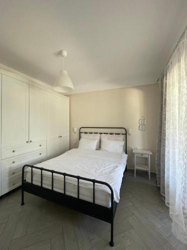 a bedroom with a bed with white sheets and a window at Renissa's Beach Suite in Vlorë
