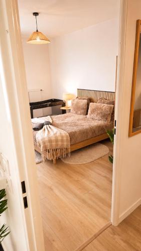 a bedroom with a bed and a couch in a room at Élégant T2 à La Queue en Brie in La Queue-en-Brie