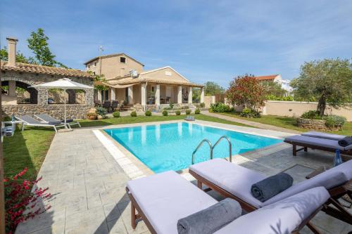 a swimming pool with chairs and a house at Pavlos & Sofia Harmony Villa with Private Pool in Corfu