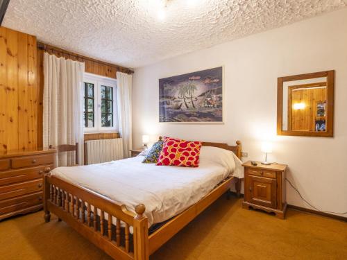 a bedroom with a bed with a red pillow on it at Apartment Casa Rossa by Interhome in Madesimo