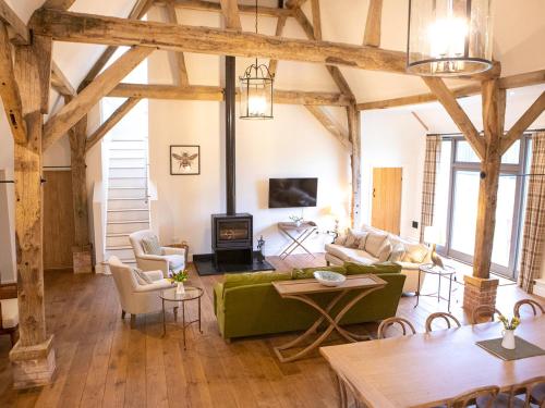 a living room with wooden beams and a green couch at Olivers Barn - Uk42081 in East Garston