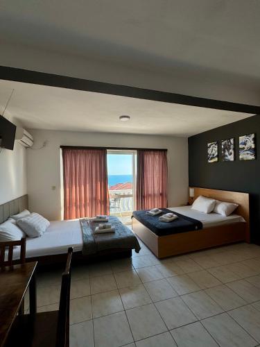 a bedroom with two beds and a large window at Apartments Adriatik in Ulcinj