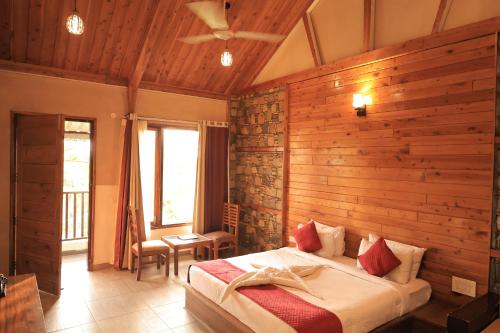 a bedroom with a bed and a wooden wall at The Corbett Manral Resort in Rāmnagar