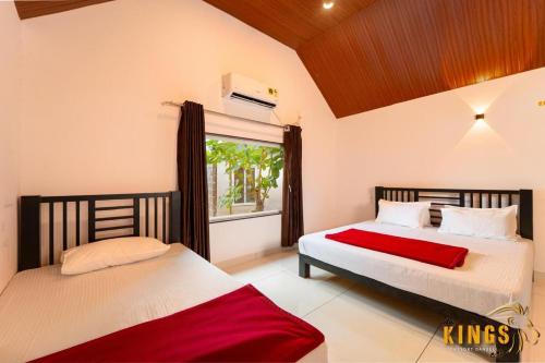 a bedroom with two beds and a window at KINGS RESORT DANDELI in Dandeli