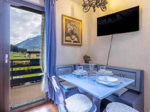 a blue table with chairs and a television on a balcony at Apartment Casa Cavalieri by Interhome in Valdisotto