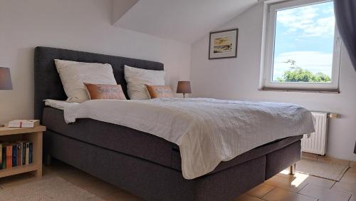 a bedroom with a large bed and a window at Meerferienwohnungen Kühlungsborn in Kühlungsborn