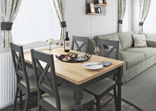 a dining room table with chairs and a couch at Trossachs Holiday Park in Gartmore