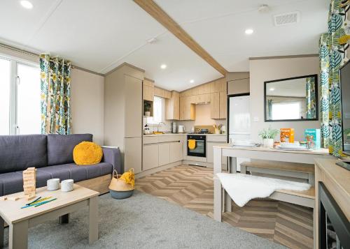 a living room with a couch and a kitchen at Trossachs Holiday Park in Gartmore
