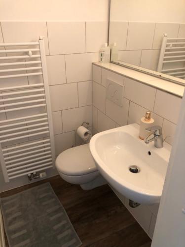 a white bathroom with a toilet and a sink at Casa Müller in Lissendorf
