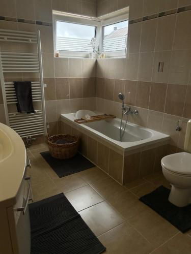 a bathroom with a tub and a toilet at La Vie est Belle chambre d hôte in Verviers