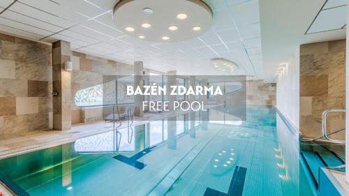 a swimming pool with a sign that reads bazaar jamaica free pool at Amenity Hotel & Resort Lipno in Lipno nad Vltavou