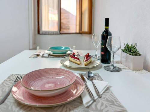 a table with a plate of cake and a bottle of wine at Studio Piccolo Mondo by Interhome in Lovran