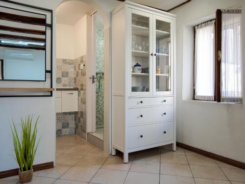 a white cabinet in a bathroom with a shower at Studio Piccolo Mondo by Interhome in Lovran
